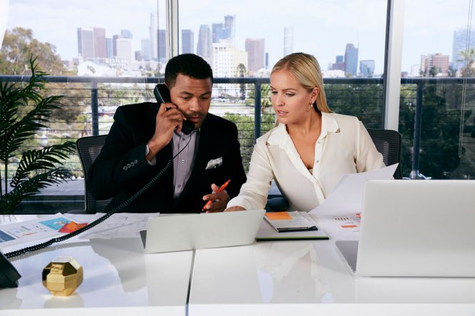 A man and a woman sitting at a desk.