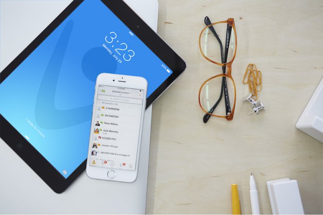 A smartphone, tablet, and pair of glasses on a desk.