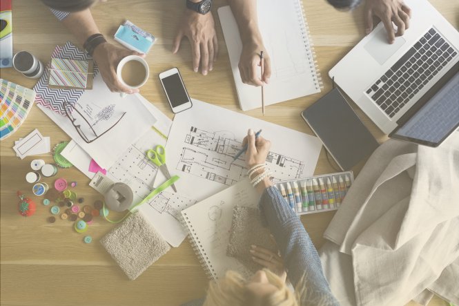 Colleagues reviewing documents with a laptop and a smartphone.