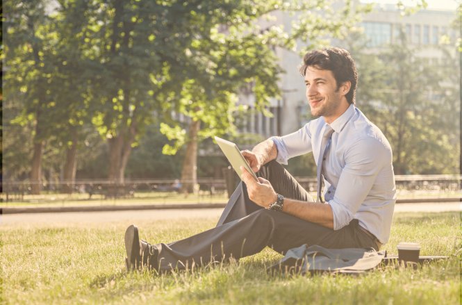 A man using his tablet in a park thanks to cloud solutions for business.