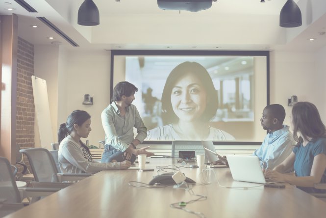 Men and women enjoying high QoS for video conferencing.