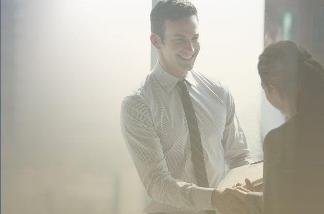 A businessman closes a deal with a customer he found through creating customer personas