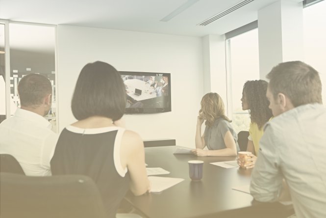 Employees of a credit union watch a training session using bank video conferencing