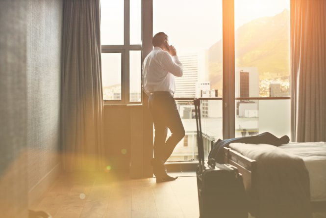 Person talking on smartphone in a hotel room about improving a net promoter score