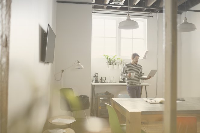 Employee in their kitchen exemplifying work-from-home trends while working on a laptop