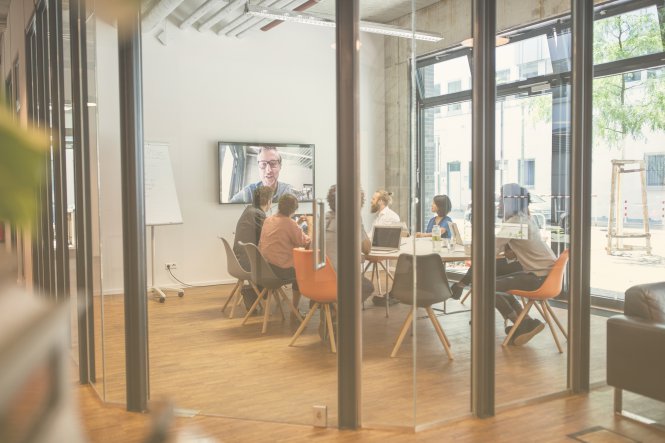 Group of employees using video conferencing infrastructure to talk with remote colleague