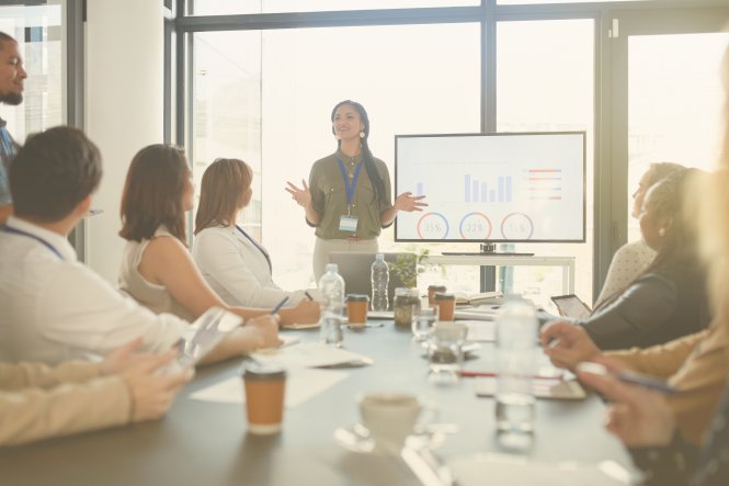 Business leader presenting to employees using communication technology in conference room