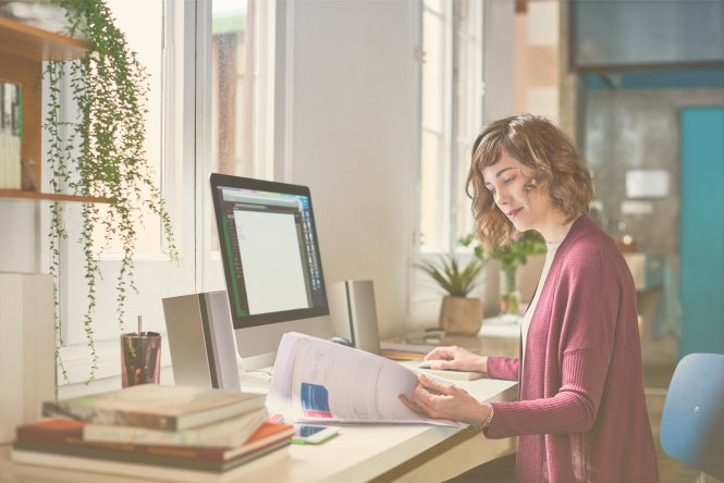Employee using the benefits of UCaaS to work from home at a desk and desktop computer