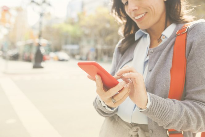 Person in a suit using a smartphone in the street — CRM utilization
