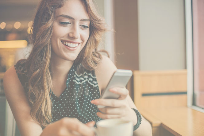 Person smiling and using messaging strategies on smartphone to contact business