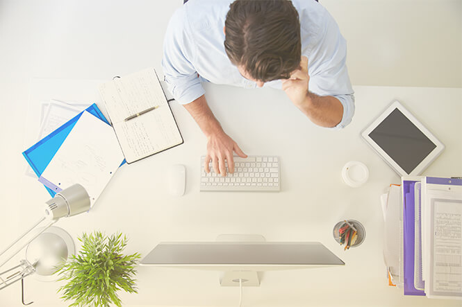 Businessperson using new enterprise communications services through laptop and mobile device.