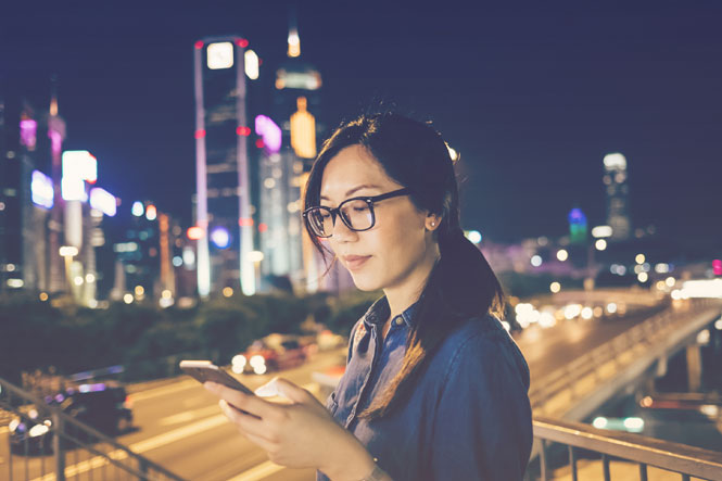 Traveler looking at app on phone via a hotel API integration