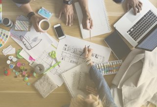 Colleagues reviewing documents with a laptop and a smartphone.