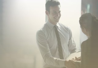 A businessman closes a deal with a customer he found through creating customer personas