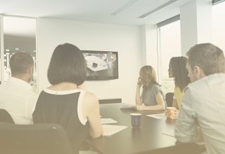 Employees of a credit union watch a training session using bank video conferencing