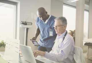 A male physician and male nurse discuss healthcare marketing solutions