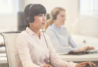 A woman wearing a phone headset providing airline contact center solutions to a customer