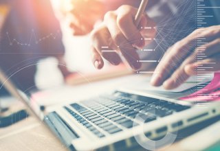 Keyboard with background of financial charts representing how to increase productivity of employees