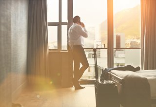 Person talking on smartphone in a hotel room about improving a net promoter score