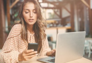 Student uses video conferencing on laptop and smartphone to communicate with online tutor