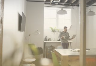 Employee in their kitchen exemplifying work-from-home trends while working on a laptop