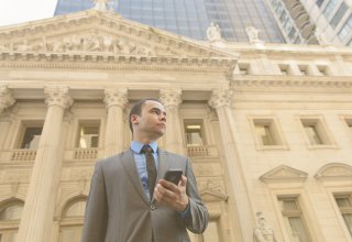 Lawyer outside courthouse on phone for law firm management