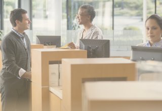 Bank employee with skills for finance jobs serving a customer at the counter