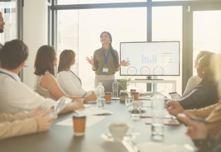 Business leader presenting to employees using communication technology in conference room