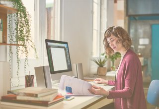 Employee using the benefits of UCaaS to work from home at a desk and desktop computer