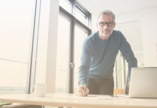 Person at desk with pen in hand building a business case for enterprise UCaaS