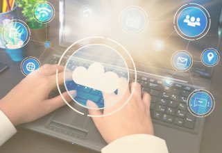 Person typing on a laptop with symbols representing cloud migration