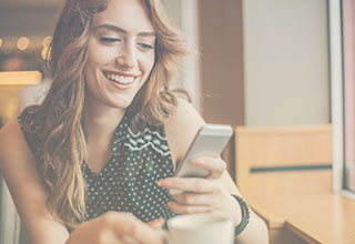 Person smiling and using messaging strategies on smartphone to contact business