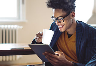 A remote worker on laptop holding a mobile phone
