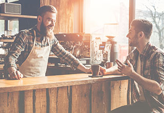 Barista smiling and talking with coffee shop customer — top customer service quotes